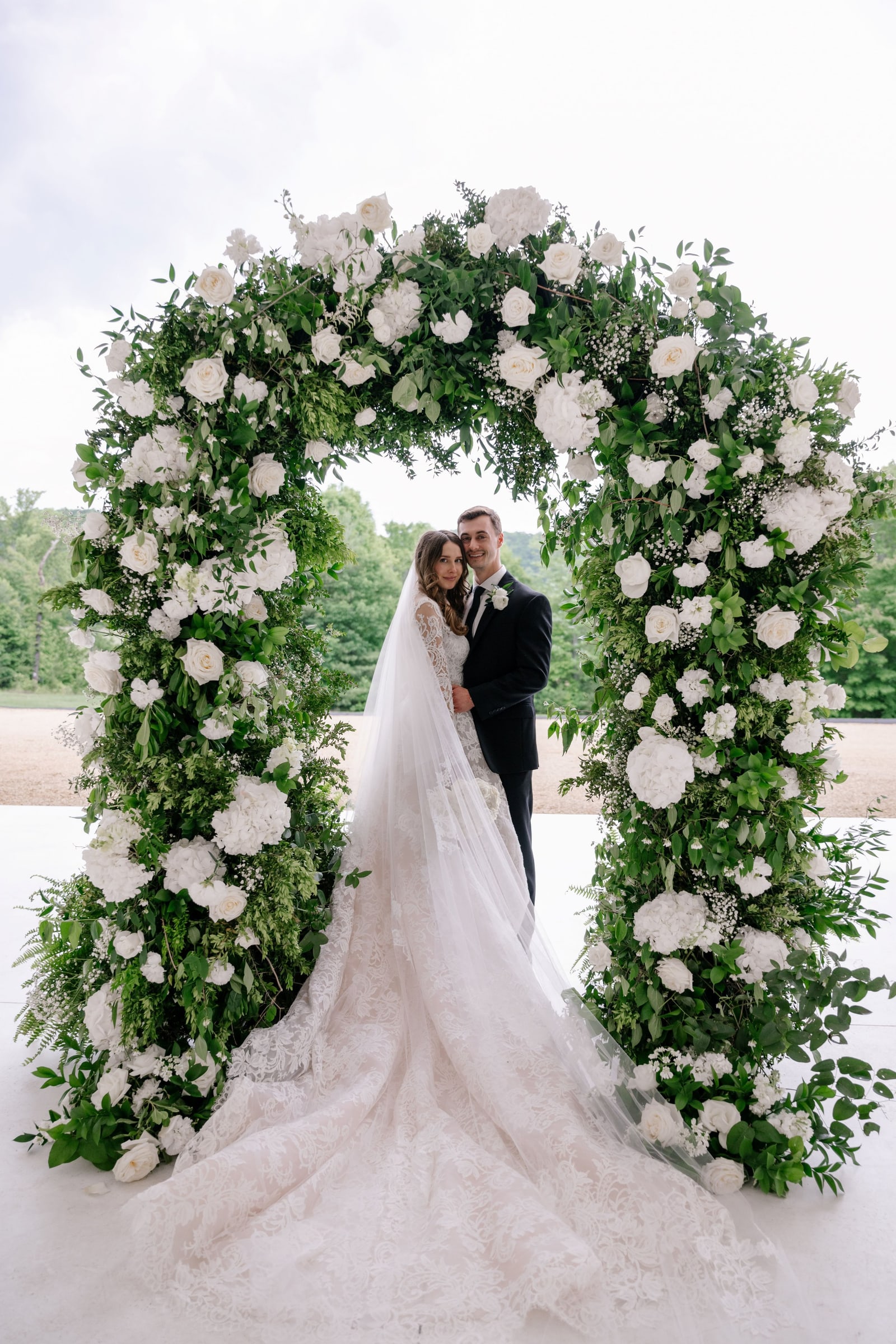 Couple under a floral arch by Florals by Kimberly